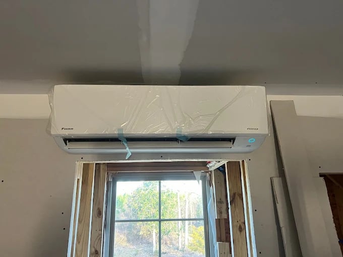 White ductless mini-split air conditioner mounted above a window