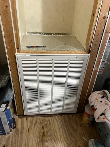 Wooden-framed air return vent with exposed wall and wooden floor