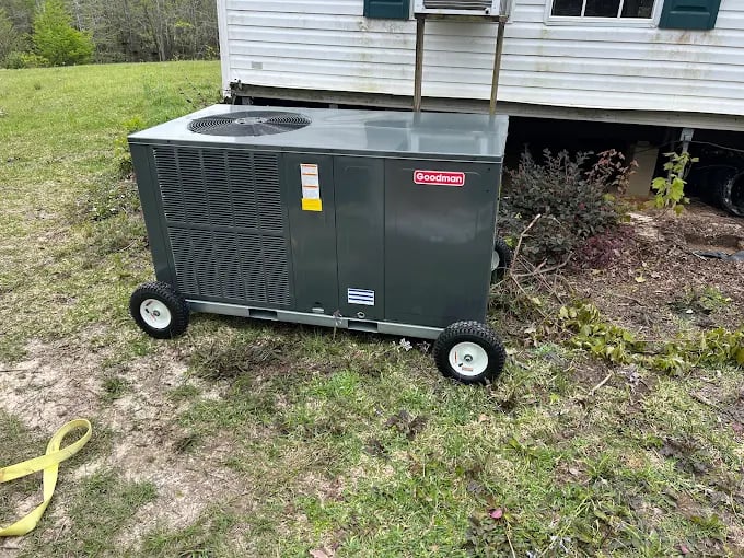 Goodman HVAC unit on wheels beside a white house with green shutters