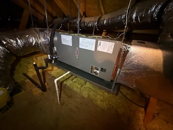 HVAC system installed in attic with insulated ductwork and wooden beams