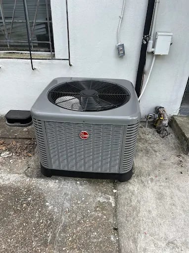 Gray Rheem air conditioning unit installed on concrete outside building